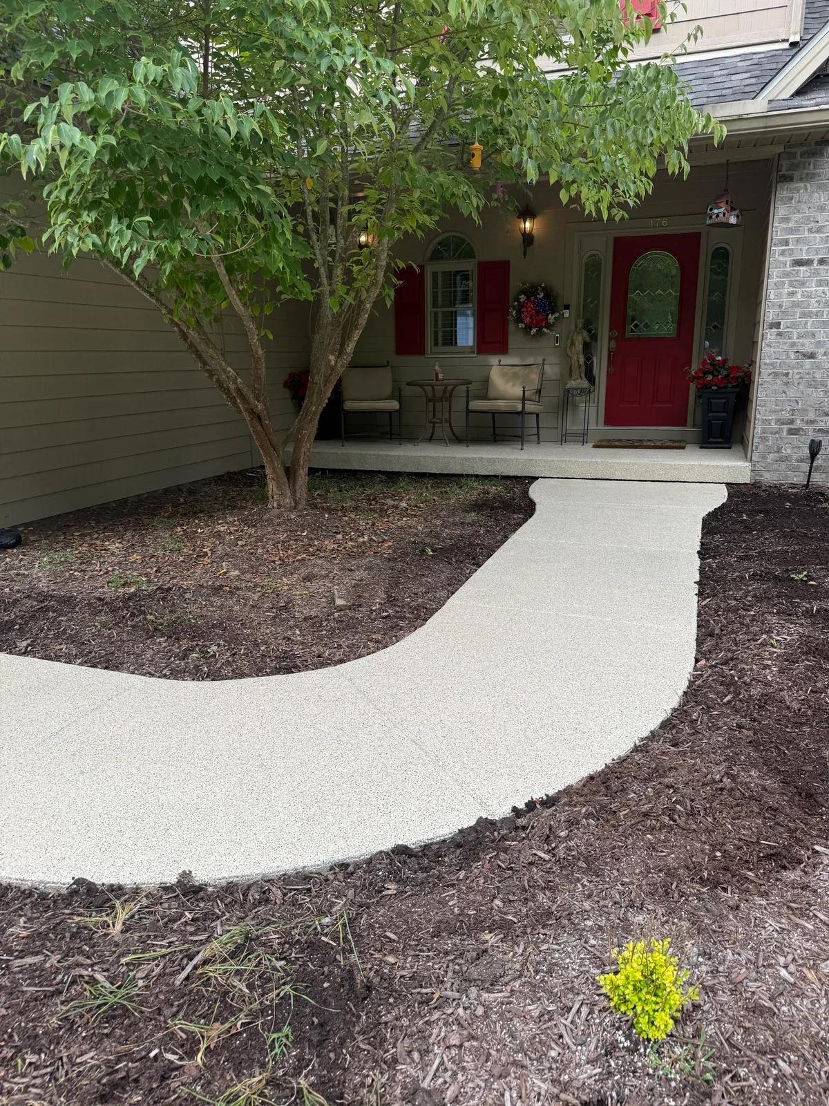 Light decorative-flake walkway curving toward the front porch in Glade Springs, Daniels, West Virginia