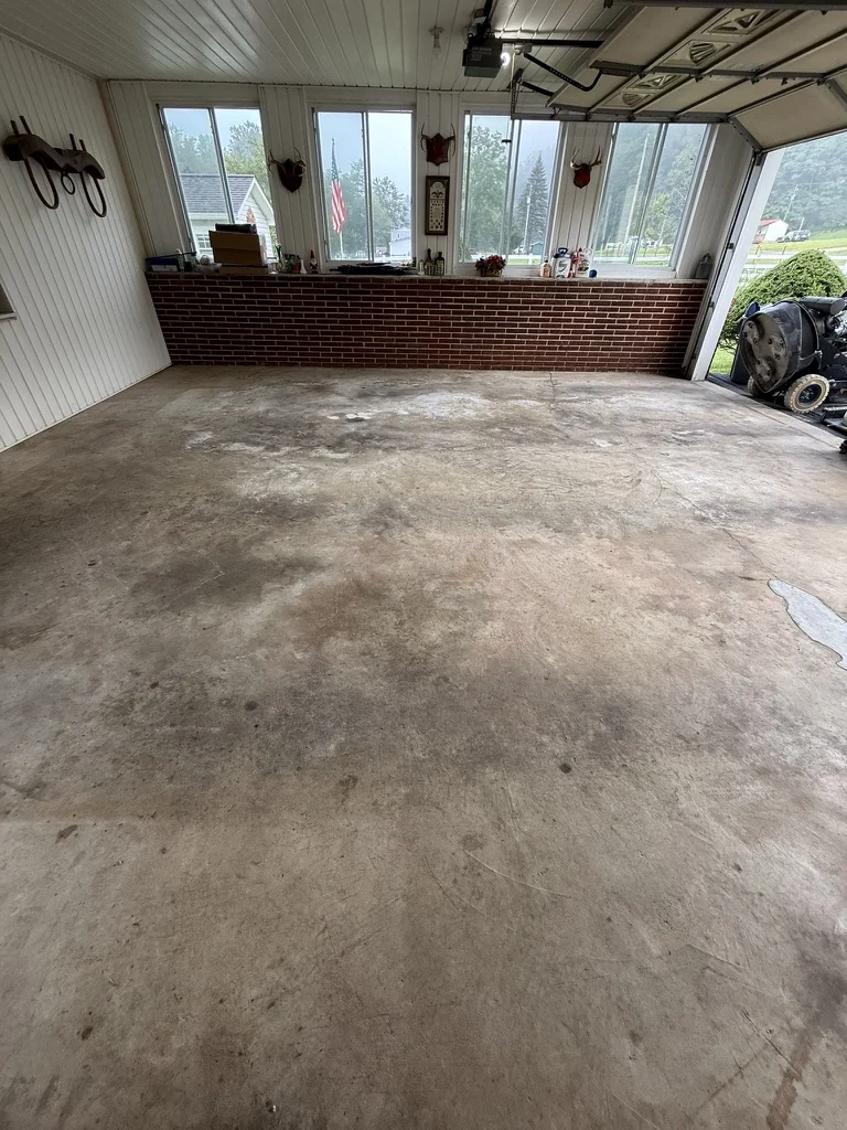 Before — Worn concrete and patched areas along the window wall of the Wytheville garage.