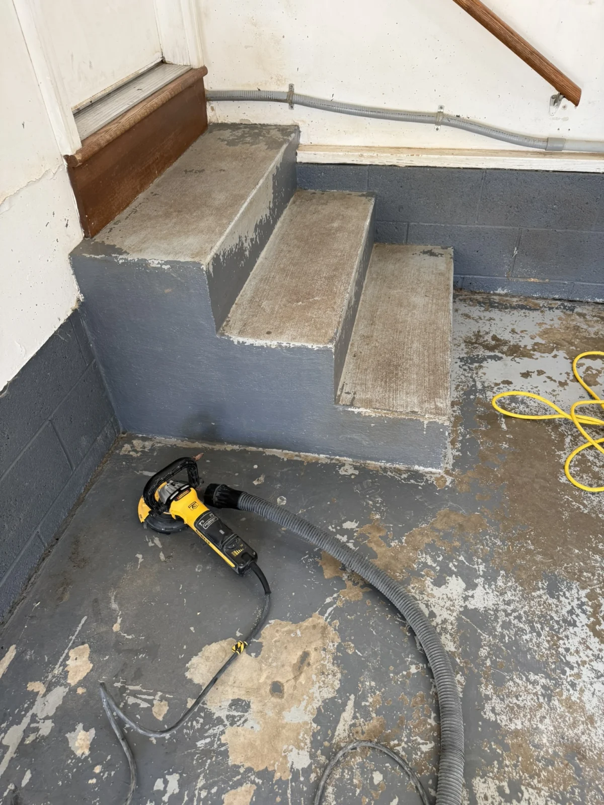 Peeling DIY epoxy on the garage entry steps before replacement in Charleston, WV.