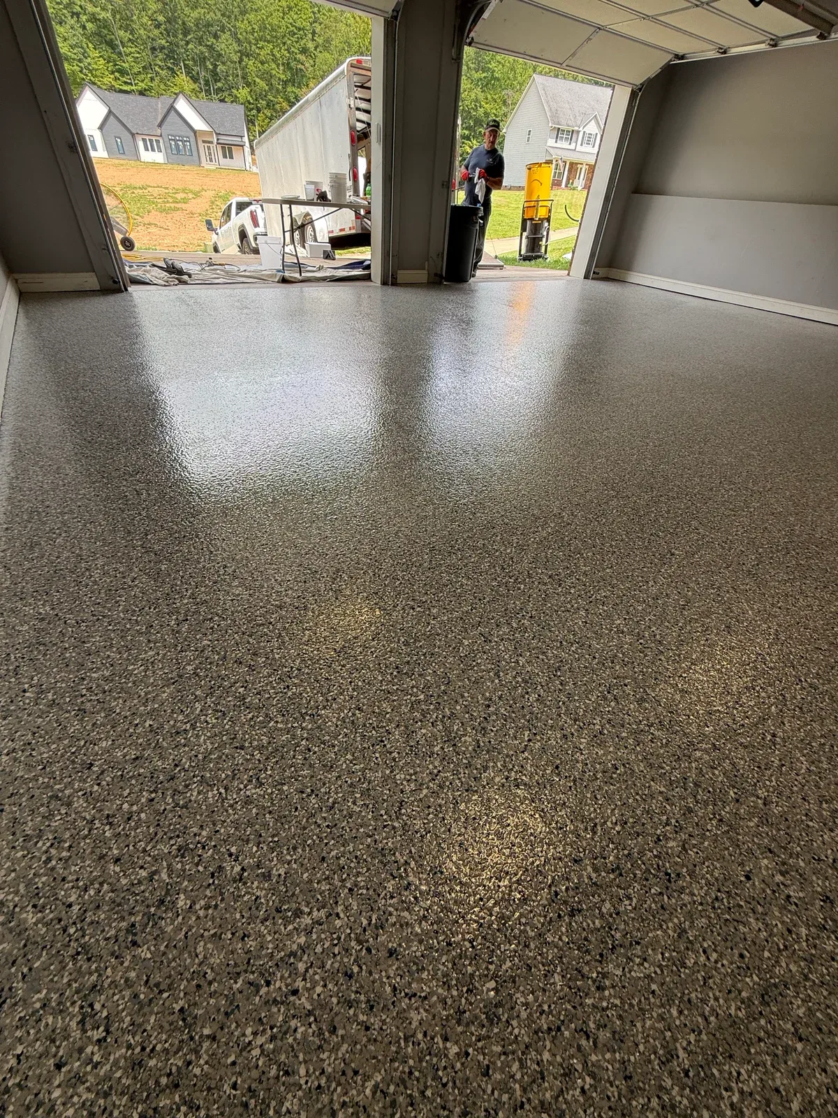 Finished Stonewash decorative-flake garage floor looking toward the open garage doors in Charleston, West Virginia