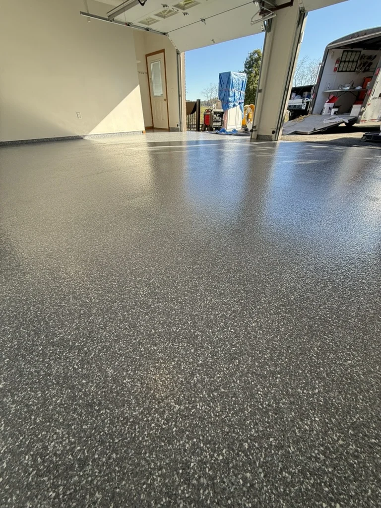 Low-angle view of the completed Custom Blizzard garage floor toward the doors