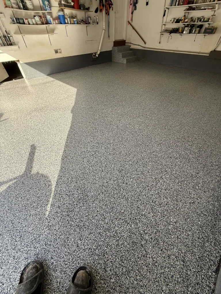 Finished garage floor and matching entry steps viewed from the doorway.