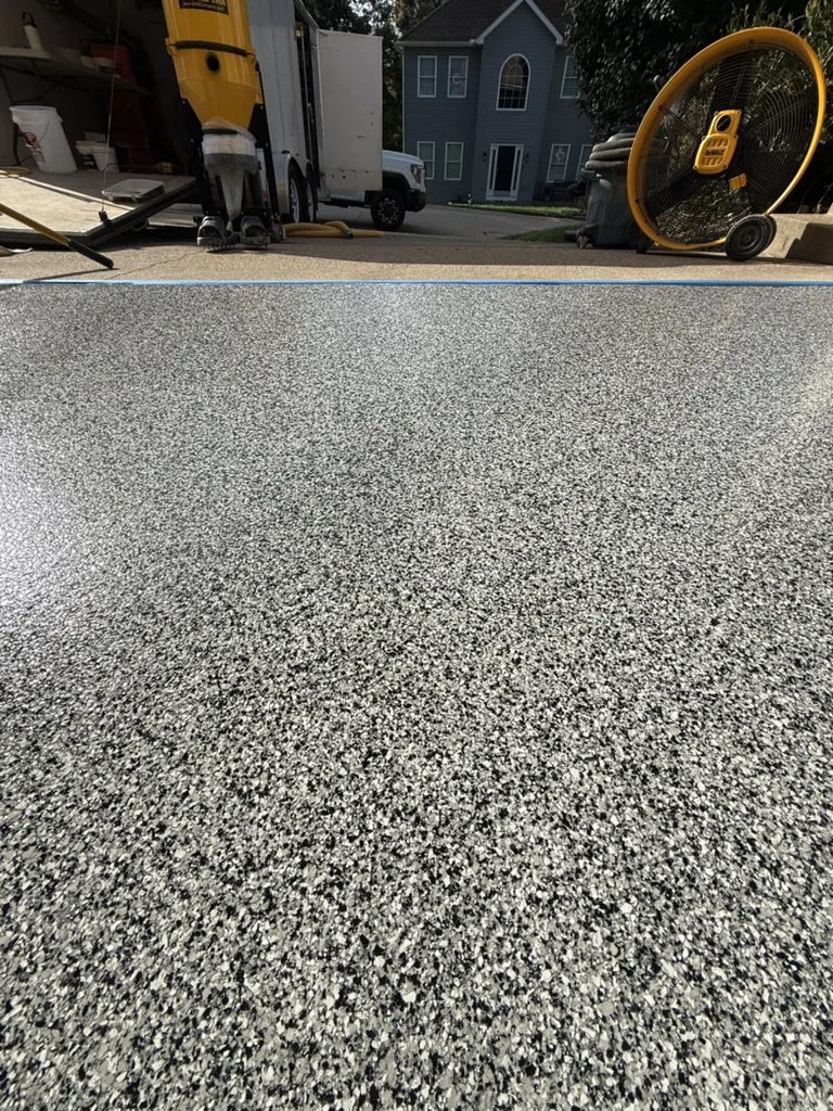 Close view of the decorative flake finish at the garage threshold.