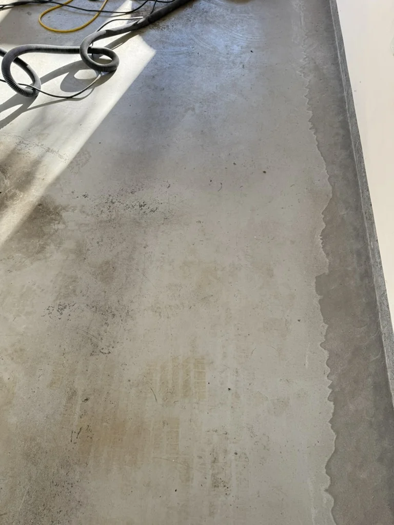 Concrete preparation along the garage wall after removing the old coating