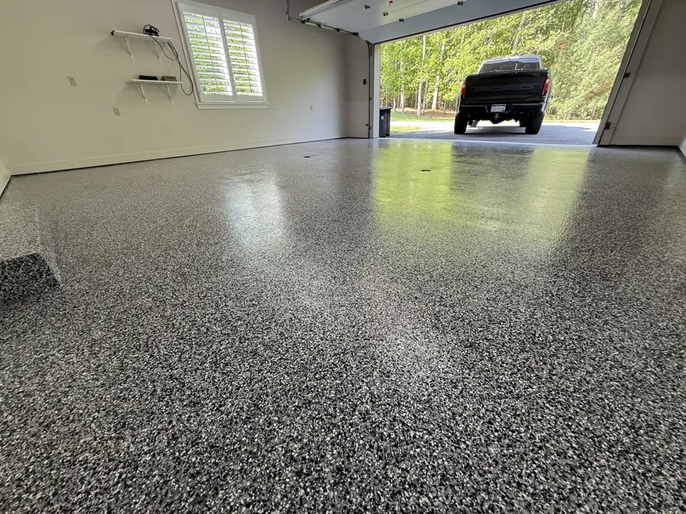 A completed Epoxy King gray flake garage floor with the door open