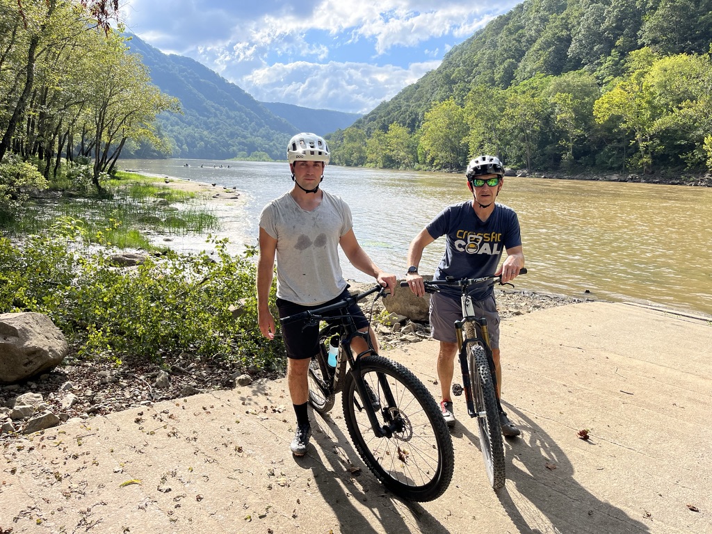 Steven and his Epoxy King business partner Bryon with their mountain bikes beside a river