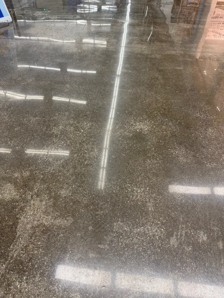 Close view of polished concrete with visible aggregate and reflected overhead lights
