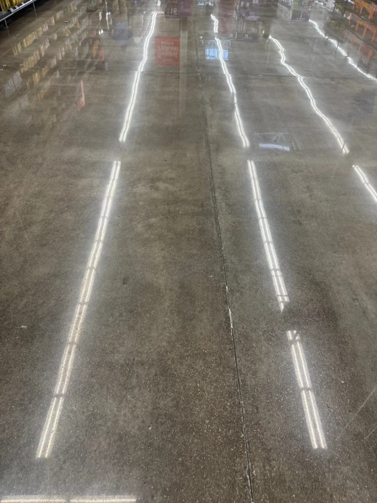 Polished concrete aisle showing natural color variation and overhead light reflections